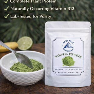 May include: A white pouch of "WOLFFIA POWDER" with a green powder inside, next to a bowl of the same powder. The text reads "PLANT-BASED SUPERFOOD POWDER", "Vegan", "Non-GMO", and "Gluten-Free". The net weight is 1.76 oz / 50g.