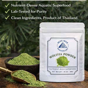May include: A white pouch of Wolffia Powder, a nutrient-rich superfood, sits on a wooden surface. A bowl and scoop filled with green powder are next to the pouch. Text on the pouch reads "Natural Plant Protein & Vitamin B12".