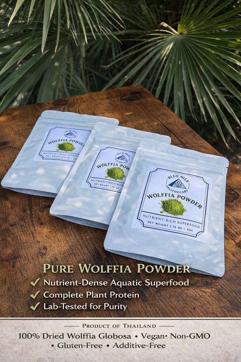 May include: Three light blue pouches of Wolffia Powder, a nutrient-rich aquatic superfood, are displayed on a wooden surface. Each pouch features a label with the product name, a green powder image, and the text "Nutrient-Rich Superfood, Net Weight 1.76 oz / 50g".