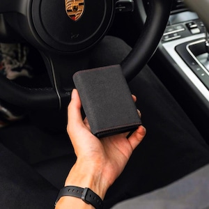 Cartera minimalista de lujo en Alcántara negra con tarjetero desplegable y garantía de por vida.