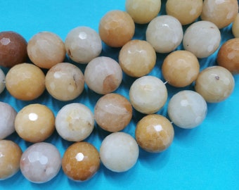 Könnte beinhalten: Eine Kette aus facettierten, runden, beige und weißen Perlen. Die Perlen sind aus Naturstein und haben eine polierte Oberfläche.