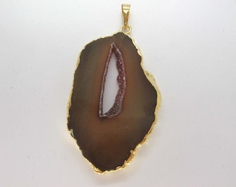 May include: A gold-plated pendant featuring a brown agate slice with a white and pink crystal formation in the center.