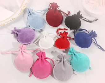 Könnte beinhalten: Sortiment von 12 kleinen Kordelbeuteln in verschiedenen Farben, darunter Rot, Blau, Rosa, Lila, Grau und Weiß. Die Beutel sind aus weichem Stoff gefertigt und eignen sich perfekt zum Verstauen von kleinen Gegenständen wie Schmuck, Geschenken oder Gastgeschenken.