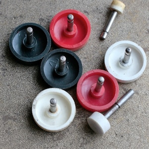 Könnte beinhalten: Sortiment aus sechs runden, plastischen Kreiseln mit Metallachsen. Die Kreisel sind in den Farben Schwarz, Weiß und Rot.