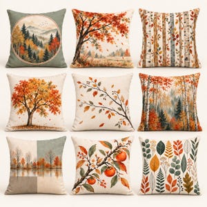 May include: A set of nine square throw pillows featuring various autumn-themed designs, including landscapes with mountains, forests, birch trees, and detailed illustrations of fall foliage, branches, and orange persimmon fruits on a light background.