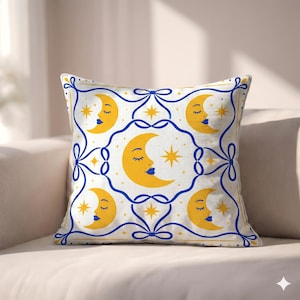 May include: A square throw pillow featuring a white background with a repeating pattern of yellow crescent moons with closed eyes and blue lips, interspersed with yellow four-pointed stars, all framed by interconnected blue ribbon-like lines.