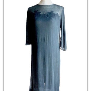 May include: A sheer black maxi dress with a beaded design on the bodice.