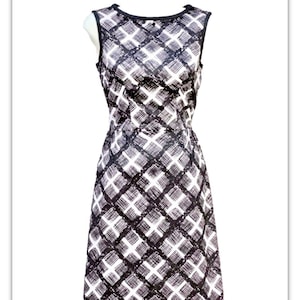 May include: A sleeveless black and white dress with a geometric pattern. The dress has a fitted bodice and a flowing skirt.