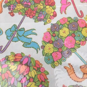 Puede incluir: Un diseño de papel de regalo vintage con coloridos ramos de flores dispuestos en forma de paraguas. Los ramos están compuestos por flores rosas, amarillas, azules, verdes y naranjas con detalles dorados.