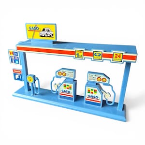 May include: A blue toy gas station with red and white accents. The sign reads "GASO" with a car graphic. Features include gas pumps, a customer service sign, and a 24-hour service sign. The toy is made of plastic.