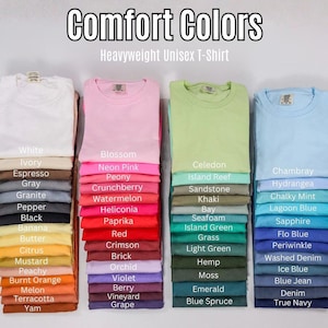 K&ouml;nnte beinhalten: Vier vertikale Stapel gefalteter, schwerer Unisex-T-Shirts in verschiedenen Farben. Der Text Comfort Colors Heavyweight Unisex T-Shirt steht oben. Jedes T-Shirt ist mit seinem Farbnamen beschriftet, von Wei&szlig; bis Marineblau.