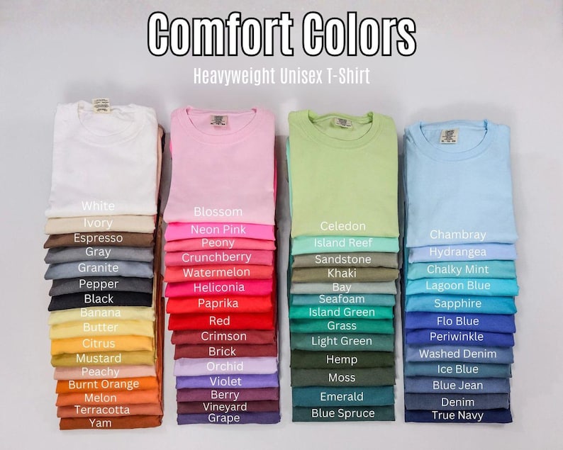 K&ouml;nnte beinhalten: Vier vertikale Stapel gefalteter, schwerer Unisex-T-Shirts in verschiedenen Farben. Der Text Comfort Colors Heavyweight Unisex T-Shirt steht oben. Jedes T-Shirt ist mit seinem Farbnamen beschriftet, von Wei&szlig; bis Marineblau.