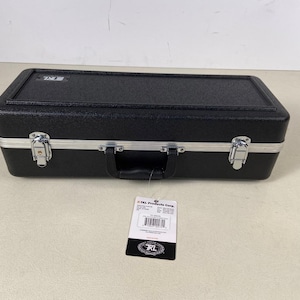 May include: A black rectangular case with a textured surface, silver trim, and two metal latches. It has a black handle and a tag attached. The case appears to be made of a durable material.