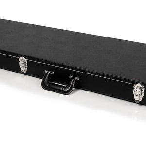 May include: A black rectangular case with a handle and silver latches. The case has white stitching around the edges and a textured surface. The case is designed to protect musical instruments.
