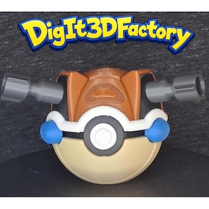 May include: A spherical toy with a brown top, tan bottom, and a central white button surrounded by a black ring. It features two gray cylindrical protrusions on the sides and blue accents. The text DigIt3DFactory is displayed above the object.