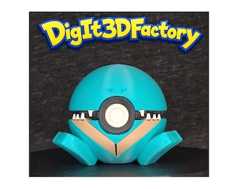 May include: A 3D-printed, teal-colored robot toy with a round head and a circular white and black feature in the center. The robot has a mouth-like opening with white teeth and tan accents. The text "DigIt3DFactory" is above the robot.