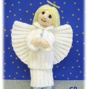 May include: A white knitted angel doll with a halo, wings, and a long white dress. The doll is standing on a blue background with gold stars.