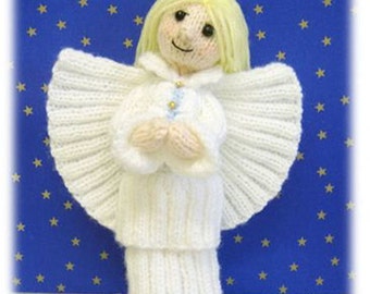 May include: A white knitted angel doll with a halo, wings, and a long white dress. The doll is standing on a blue background with gold stars.