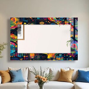 May include: A large, rectangular wall mirror with a vibrant, abstract design in a variety of colors, including blue, yellow, and red. The mirror is framed with a complex pattern, and is mounted above a white sofa with colorful pillows.
