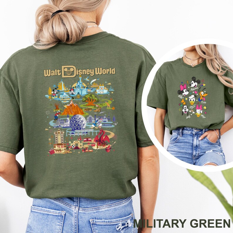 Op de afbeelding: Militairgroen t-shirt met een kleurrijke afbeelding van Disney World-bezienswaardigheden en -personages. De achterkant van het shirt toont de woorden "Walt Disney World" boven een gedetailleerde illustratie van het park. De voorkant toont Mickey, Minnie, Donald, Daisy en Goofy.