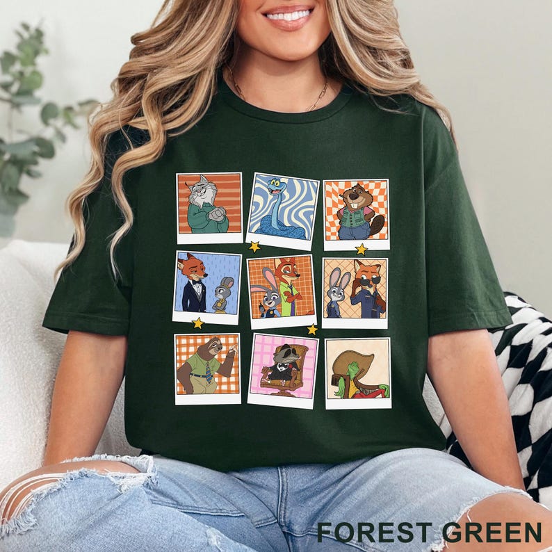 Pode incluir: Camiseta verde floresta com uma grade de retratos de personagens de desenhos animados em estilo polaroid. Os retratos incluem um gato, uma cobra, um castor, uma raposa, um coelho e uma pregui&ccedil;a. O texto "FOREST GREEN" &eacute; impresso na parte inferior.
