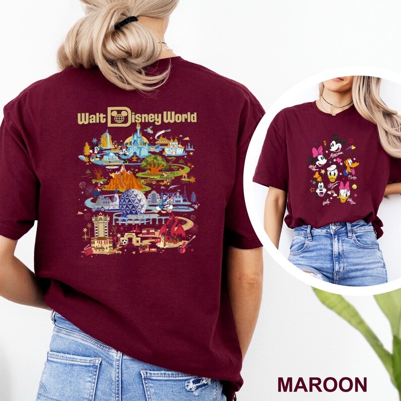 Op de afbeelding: Bordeauxrood T-shirt met een kleurrijke afbeelding van Disney World attracties en personages. De achterkant van het shirt toont de tekst "Walt Disney World" boven een gedetailleerde illustratie van het park. De voorkant van het shirt toont een afbeelding van Disney-personages.