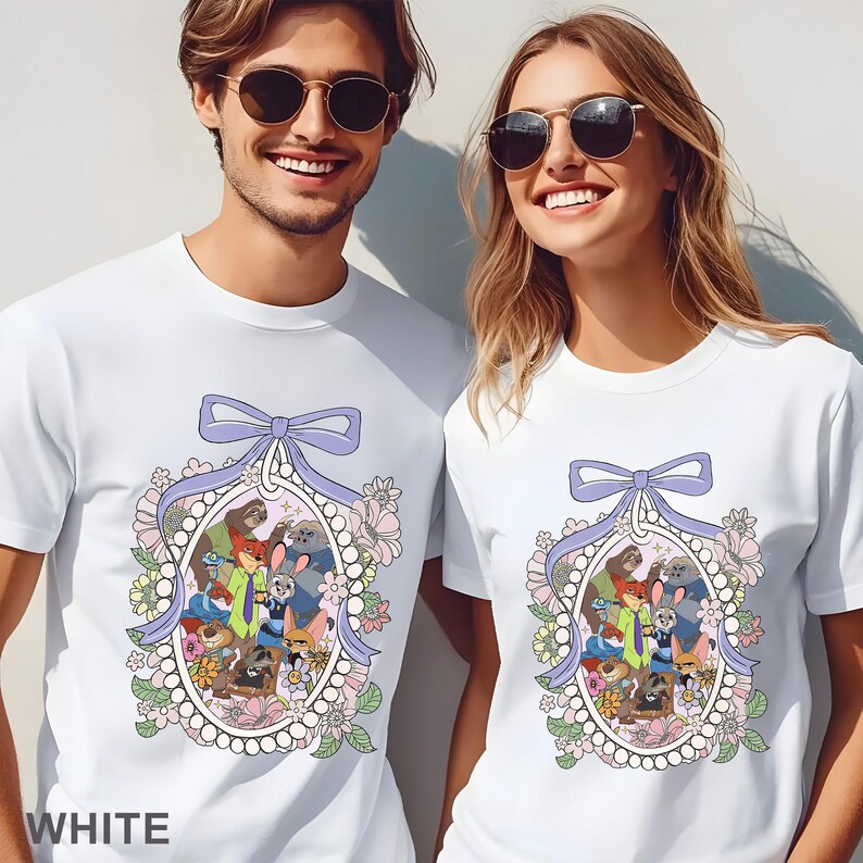 May include: White t-shirts featuring a cartoon design with various animal characters inside an oval frame. The frame is decorated with a light purple bow, flowers, and pearls. The word "WHITE" is printed at the bottom.