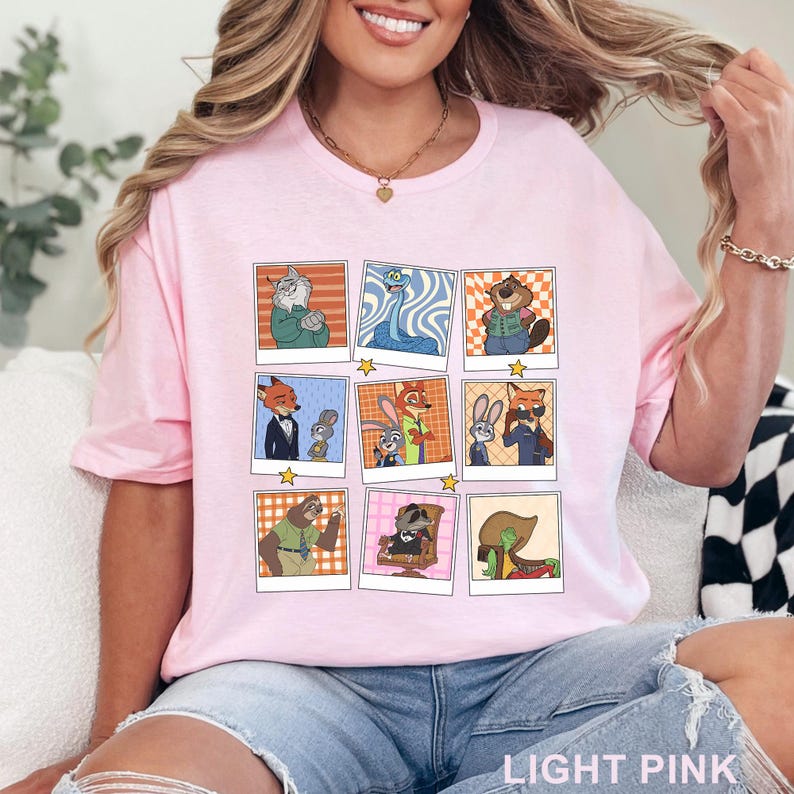 Pode incluir: T-shirt rosa claro com uma grelha de retratos de personagens de desenhos animados. Cada retrato &eacute; emoldurado em estilo polaroid com uma estrela. A camisa tem as palavras "LIGHT PINK" impressas na parte inferior.