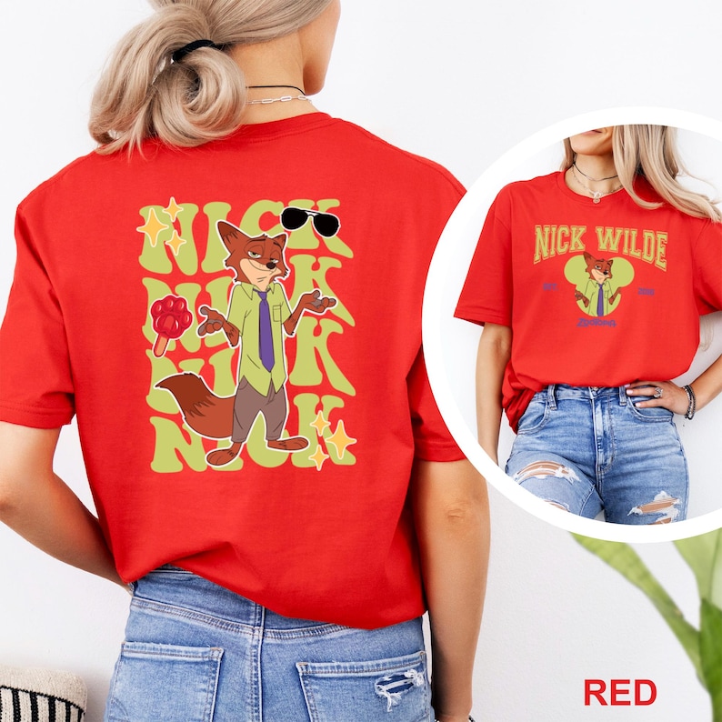 K&ouml;nnte beinhalten: Rotes T-Shirt mit einer Cartoon-Fuchsfigur mit Sonnenbrille, gr&uuml;nem Hemd und lila Krawatte. Der Text "NICK WILDE" ist auf der Vorder- und R&uuml;ckseite des Shirts in einer stilisierten Schriftart aufgedruckt. Das Shirt ist ein kurz&auml;rmeliges Rundhals-Shirt.
