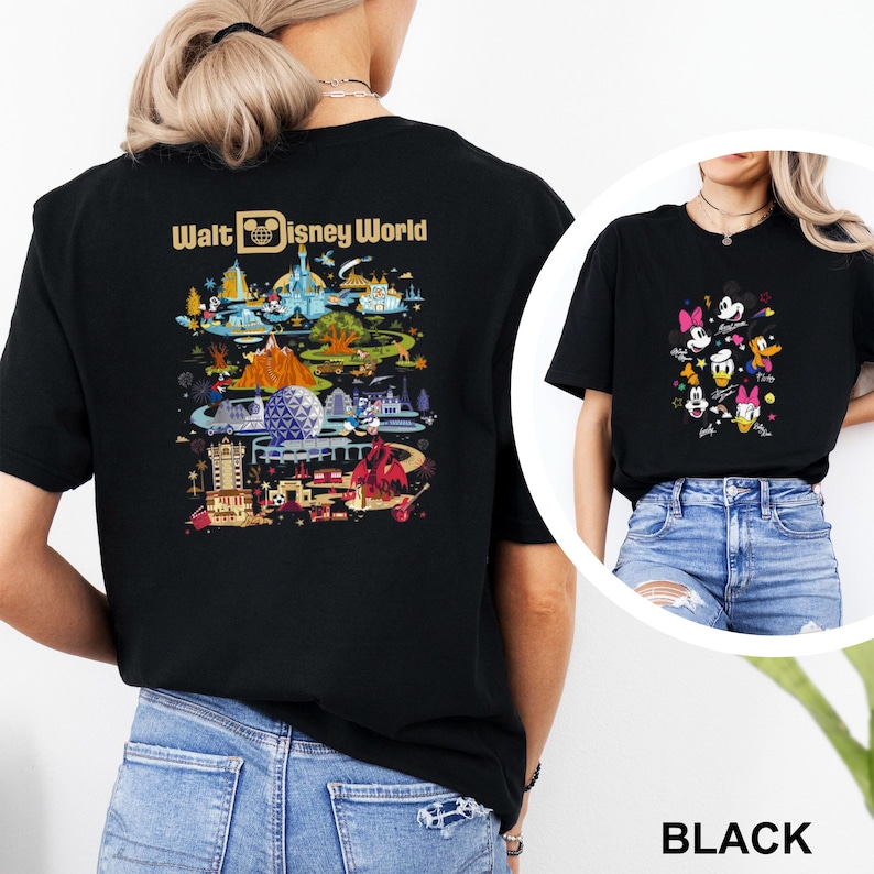Op de afbeelding: Zwarte T-shirts met Disney World-ontwerpen. E&eacute;n shirt toont een kleurrijke parksc&egrave;ne met de tekst "Walt Disney World". De andere toont Mickey Mouse, Minnie Mouse, Donald Duck, Daisy Duck en Goofy. Het woord "BLACK" is ook zichtbaar.