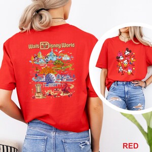Op de afbeelding: Rood T-shirt met een kleurrijke afbeelding van Walt Disney World attracties en personages. De achterkant van het shirt toont een gedetailleerde kaartachtige illustratie met de tekst "Walt Disney World". De voorkant van het shirt heeft een cartoonafbeelding van Mickey Mouse en vrienden.