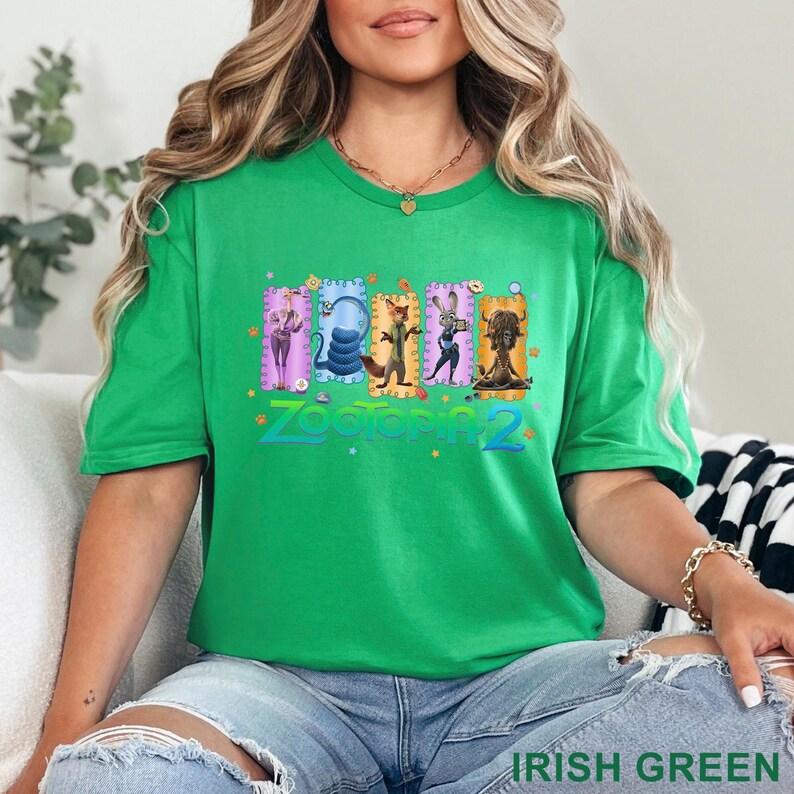 May include: Irish green t-shirt featuring a colorful graphic from the movie "Zootopia 2." The graphic includes several characters from the film. The text "Zootopia 2" is displayed in a stylized font. The shirt is a crew neck and is made of a soft material.