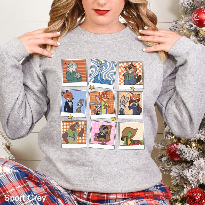May include: Sport Grey sweatshirt featuring a grid of cartoon character images. The images are in a polaroid style with a white border and a star in the corner. The sweatshirt is a light gray color.