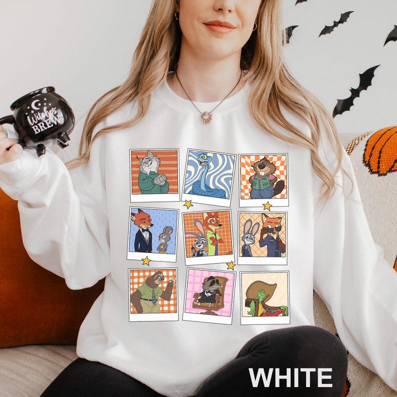 May include: White sweatshirt featuring a grid of cartoon character portraits in polaroid-style frames. The characters are in various poses and settings, with a star at the bottom of each frame. The word "WHITE" is printed in large, white letters at the bottom.