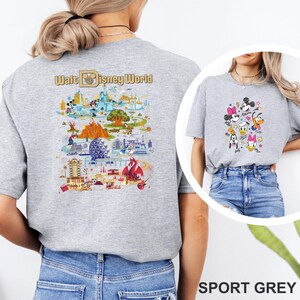 Op de afbeelding: Sportgrijs t-shirt met een kleurrijke kaart van Walt Disney World op de achterkant. De voorkant van het shirt heeft een afbeelding van Mickey Mouse, Minnie Mouse, Donald Duck, Daisy Duck, Goofy en Pluto. Het shirt is gemaakt van een zacht materiaal.