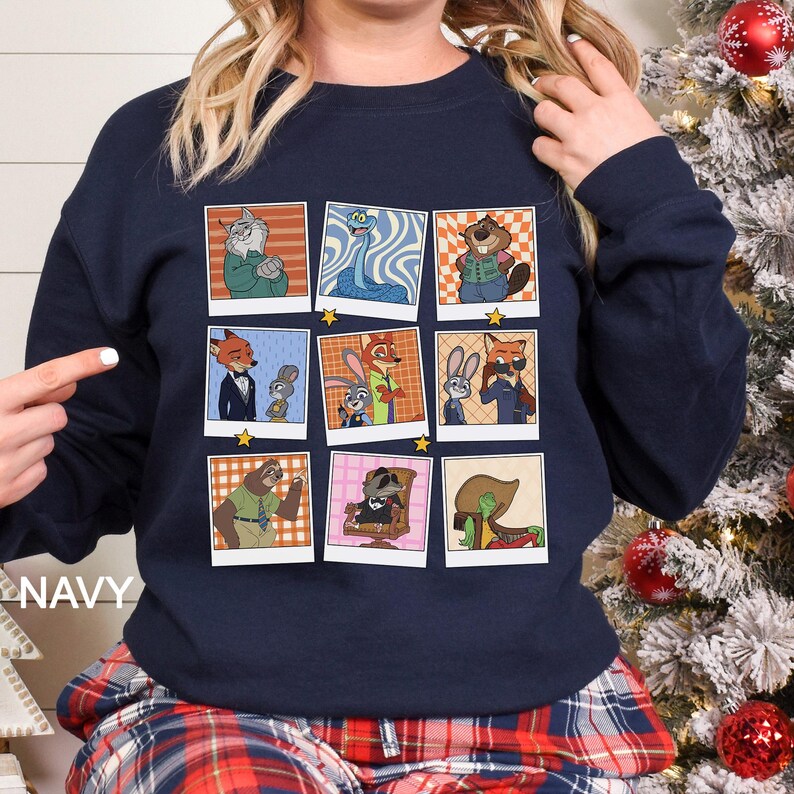 May include: Navy blue sweatshirt featuring a grid of nine cartoon character portraits. Each portrait is framed with a white border and a gold star. The characters are anthropomorphic animals in various outfits and poses. The word "NAVY" is printed on the left side.