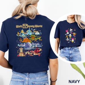 Op de afbeelding: Marineblauw T-shirt met een kleurrijke afbeelding van Disney World attracties en personages. De achterkant van het shirt toont een gedetailleerde kaart van het park met de tekst "Walt Disney World". De voorkant van het shirt heeft Disney-personages.