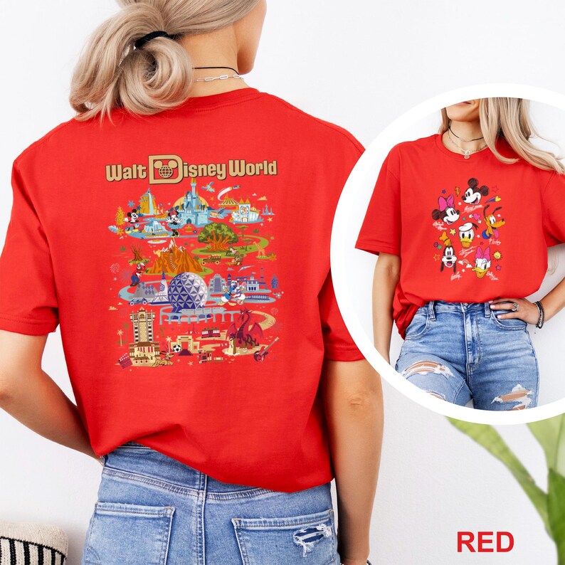 Op de afbeelding: Rood t-shirt met een kleurrijke afbeelding van Disney World attracties en personages. De achterkant van het shirt toont de woorden "Walt Disney World" boven een gedetailleerde illustratie van het park. De voorkant van het shirt heeft een afbeelding van Disney-personages.