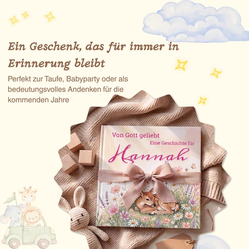 K&ouml;nnte beinhalten: Ein Kinderbuch mit dem Titel "Hannah" mit einer Reh-Illustration, gebunden mit einem Band. Das Buch liegt auf einer weichen, strukturierten Decke, mit Holzbl&ouml;cken und einem Stoffhasen in der N&auml;he. Der Text auf Deutsch lautet: "Ein Geschenk, das f&uuml;r immer in Erinnerung bleibt."