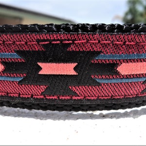 Pu&ograve; includere: Un collare per cani nero con un motivo geometrico rosso, nero e blu. Il collare &egrave; realizzato in nylon resistente e ha una fibbia in metallo robusta.