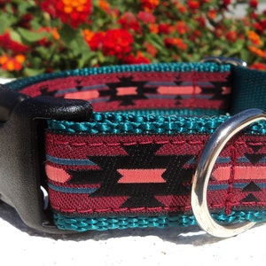 Pu&ograve; includere: Un collare per cani con motivo turchese, bordeaux, nero e rosa con una fibbia in plastica nera e un anello in metallo argentato.