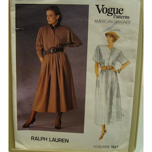 May include: Vogue Patterns sewing pattern featuring a Ralph Lauren design. The pattern includes a full-length brown dress with a belt and a button-down design. The Vogue logo and "American Designer" text are visible.