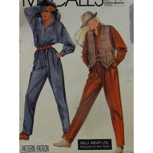 May include: A vintage sewing pattern featuring two women's jumpsuit designs. One jumpsuit is blue denim with a red belt, and the other is a rust-colored jumpsuit with a plaid vest. The pattern is from Willi Wear LTD. and designed by Willi Smith.