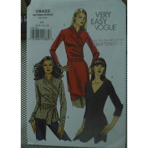 May include: Vogue pattern V8422 features three wrap-style garments. The pattern includes a red wrap dress, a black wrap top, and a patterned wrap top. The pattern size is AA (6-8-10-12). The text "VERY EASY VOGUE" is printed on the top right.
