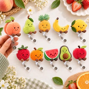 May include: A collection of ten plush fruit-themed badge reels featuring a peach, pear, pineapple, banana, lemon, strawberry, orange, watermelon slice, avocado, and apple. Each soft, textured fruit character has a smiling face and small brown feet.