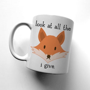 May include: White ceramic mug with a fox illustration and the text "look at all the i give."