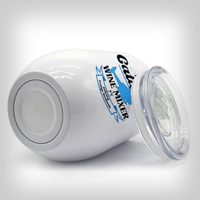 May include: White stainless steel wine tumbler with a blue and black logo that says "Gator Wine Mixer" featuring a helicopter and the words "Enjoying the Good Life Worldwide". The tumbler has a clear lid.
