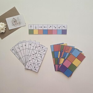 May include: Educational resources featuring arrow cards, colourful square cards, and a strip with arrows and coloured blocks. A small card with a floral illustration is also visible.