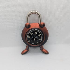 Pode incluir: Um cadeado de combinação vermelho com um grilhão prateado e um mostrador com números de 0 a 40. O cadeado tem duas pernas que se estendem para fora da parte inferior.