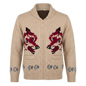 May include: Beige zip-up cardigan sweater with a shawl collar and two front pockets. The sweater features a red and black fox design on the front and a floral pattern at the bottom. The sweater is made of a soft, knitted material.